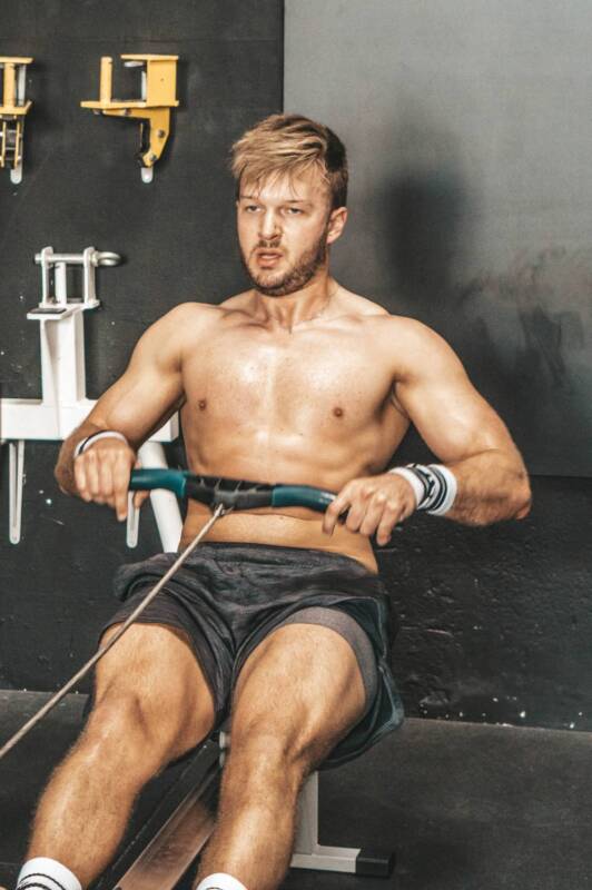 Ein Athlet ruder auf einem Ruderergometer.